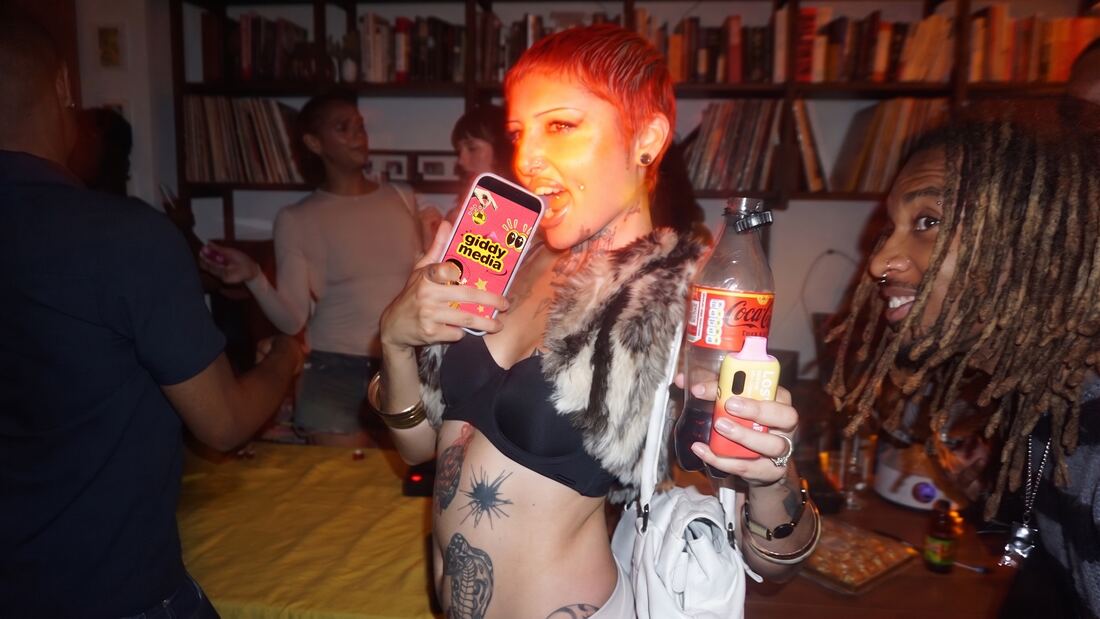Guest with red hair holding the Giddy screen